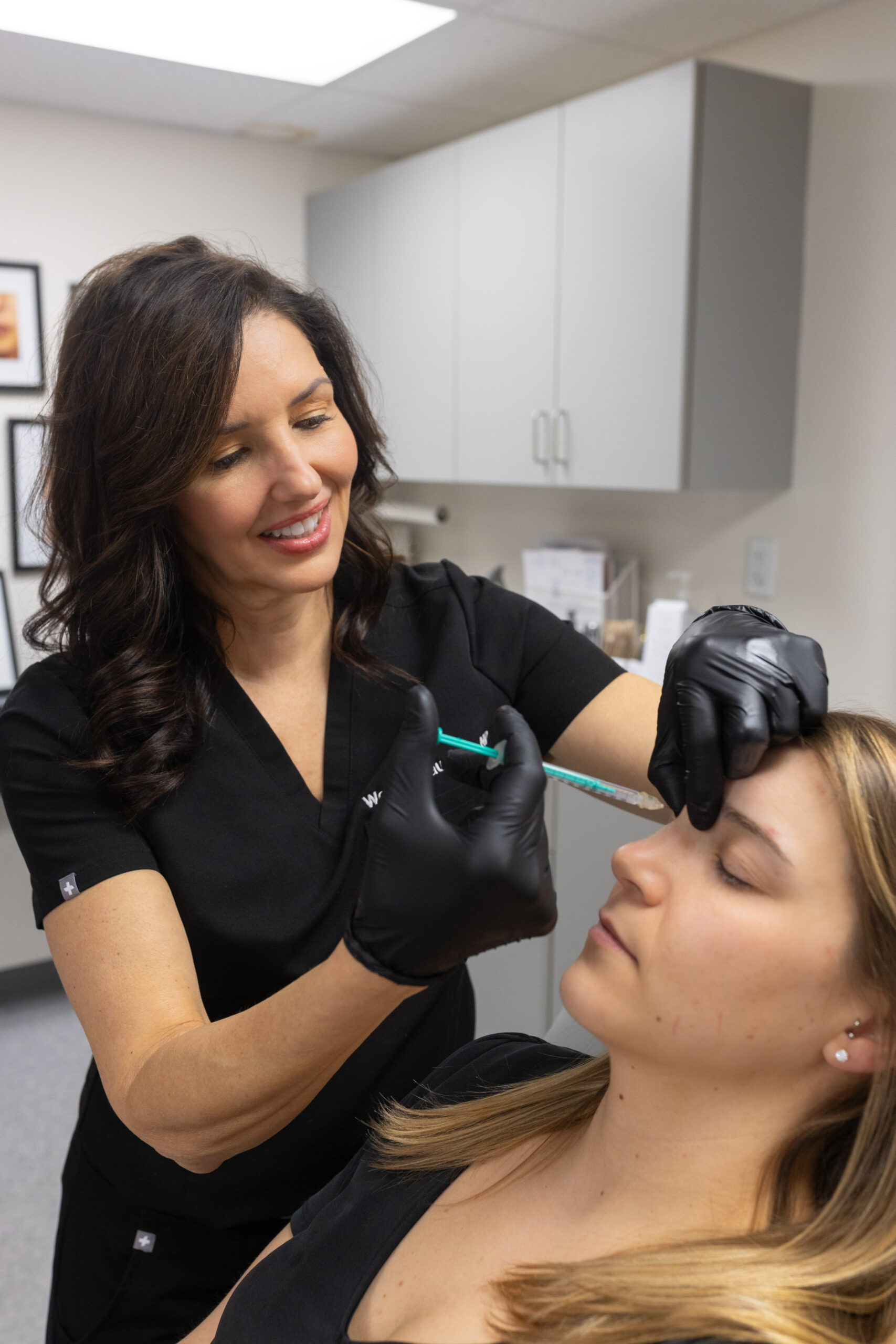 Photo of a Wendy giving injectable treatments to a patient